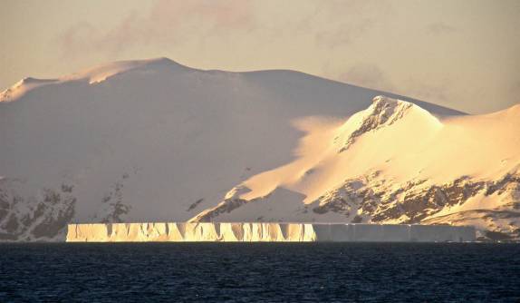 Sol ilumina um enorme iceberg tabular nas costas de Elephant Island, na Antártida (foto de Melissa Bartlett)